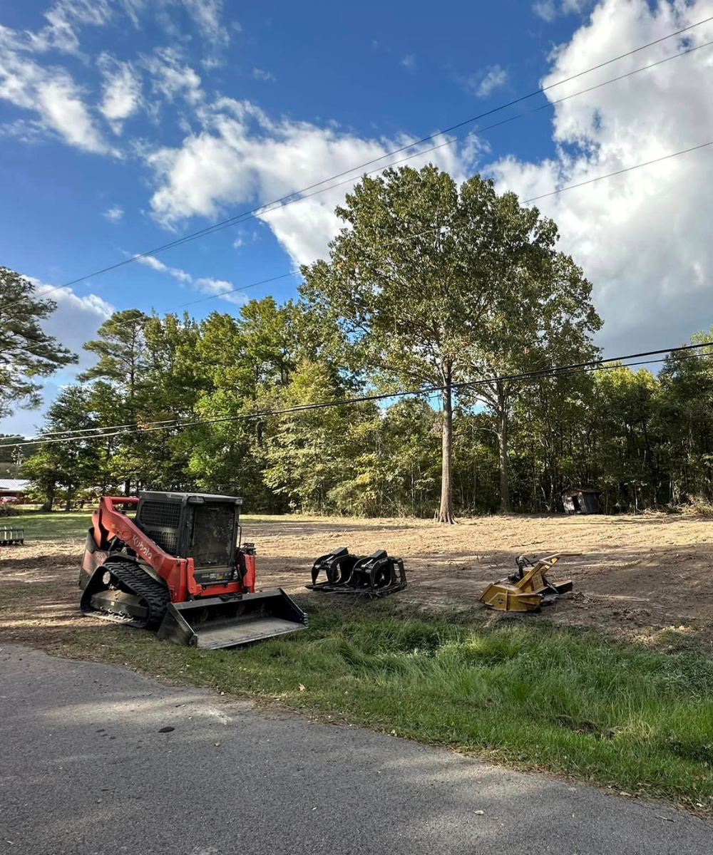 skid steer with a bucket working on clearing a project site